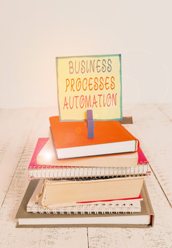 Word writing text Business Processes Automation. Business photo showcasing performed to achieve digital transformation pile stacked books notebook pin clothespin colored reminder white wooden