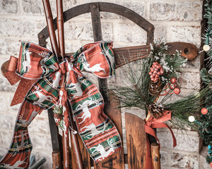 Vintage sled with rustic christmas ribbon and bow outdoors