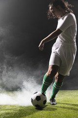 Young woman in sportswear playing soccer