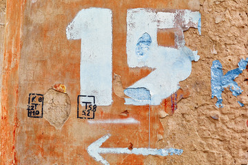 drawn number fifteen with an arrow on the old wall of the house