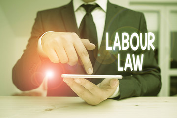 Writing note showing Labour Law. Business concept for Rules implemented by the state between...