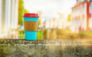 paper Cup on the curb on the background of buildings