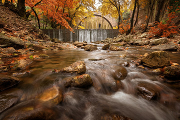 Beautiful autumn landscape.The old stone bridge of Palaiokarya and the waterfall! Trikala prefecture, Thessaly, Greece
