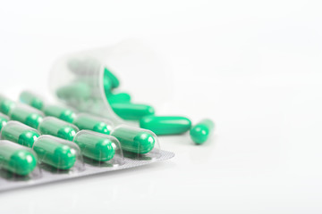 Green capsules on white background, copy-space
