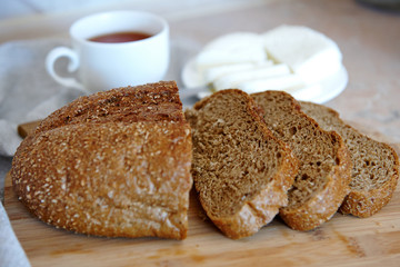 rye bread, homemade cheese, sliced for sandwiches, cup of tea, homemade cheese
