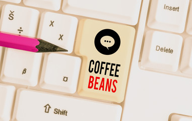 Writing note showing Coffee Beans. Business concept for pit inside the red or purple fruit often referred as a cherry White pc keyboard with note paper above the white background