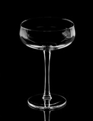transparent glass on a long stem on a black background