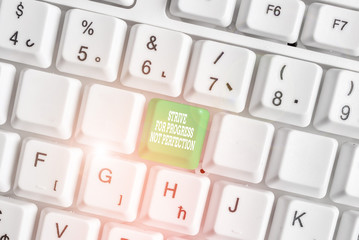 Conceptual hand writing showing Strive For Progress Not Perfection. Concept meaning Improve with flexibility Advance Grow White pc keyboard with note paper above the white background