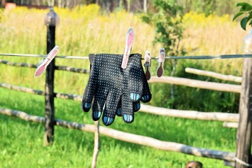 a pair of gloves to protect hands dries on a rope outdoors © dzmitry_2014