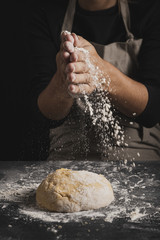 Obraz premium Close-up baker spreading flour on top of dough