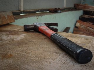 Old orange hammer on wooden table