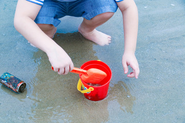 Boy hand play sands on the dirty beach