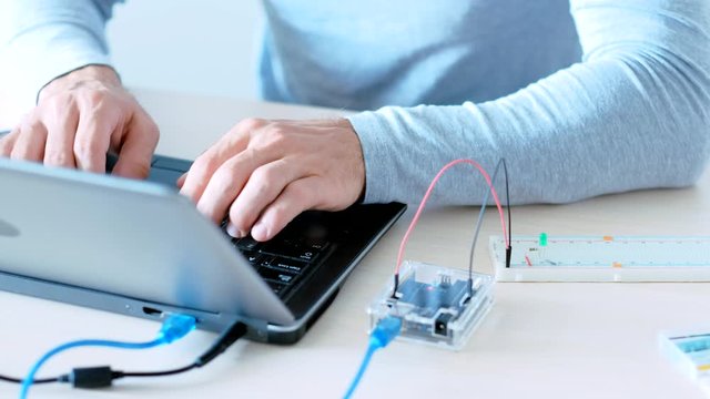 Mechatronic engineering. Internet of Things. IT programmer creating project with microcontroller.