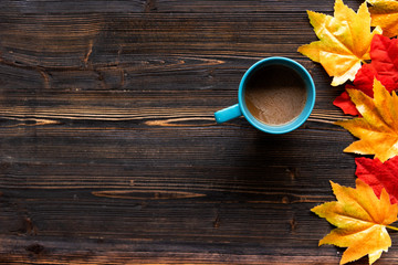 Seasonal autumn maple leaves.  Cup coffee hot steaming  warm scarf on wooden table background in morning relax sunny day. Lifestyle concept.