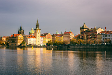 Prague Old Town on the banks of Vltava river, scenic cityscape in sunset light with reflection in the water, Czech Republic, travel background