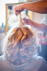 Fototapeta premium Frau wird zu Hause von Ihrer Friseurin für die Hochzeit gestyled