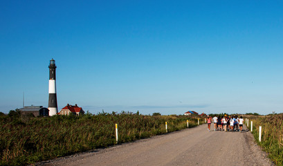 Fire Island Lighthouse with group of girls running on dirt road