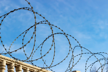Barbed wire against the blue sky.