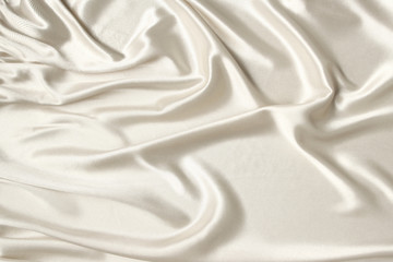 white beautiful satin fabric draped with soft folds, silk cloth background, close-up, copy space