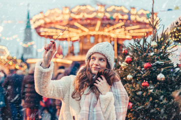 Fototapeta na wymiar Girl walking on Christmas Market on Red Square in Moscow