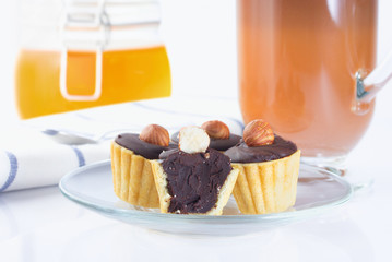 Baskets of dough, with chocolate and hazelnuts, cakes. Coffee in an Irish coffee glass, orange jam in a jar with a yoke. Linen napkin with a spoon for coffee. The photo.
