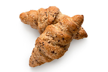 Two whole wheat croissants with linseeds and sesame seeds isolated on white. Top view.