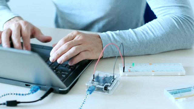Hardware development. Automation technology. IT engineer programming microcontroller board. Data flow.
