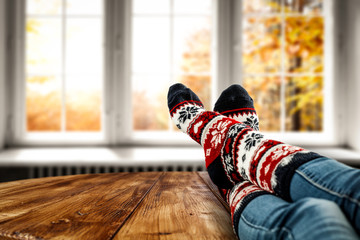 Woman legs with autumn socks and window background 