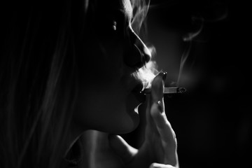 Artistic photo of a girl smoking cigarette,black and white,smoke