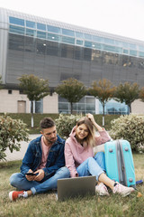 Traveling. Couple Using Phone, Waiting Transport Near Airport