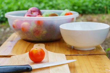 White knife with tomato fruits on wooden floor