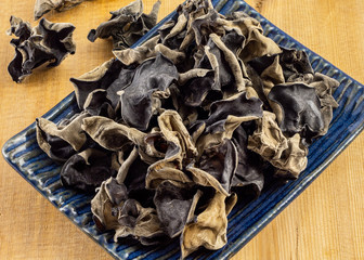 a group of wood ear, wood jellyfish, in a plate ontop of wood table.