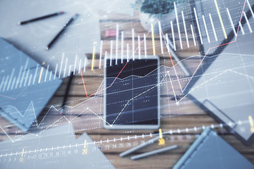 Double exposure of forex graph on digital tablet laying on table background. Concept of market analysis