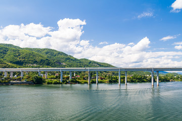 landscape of river with bridge under blue clear sky
