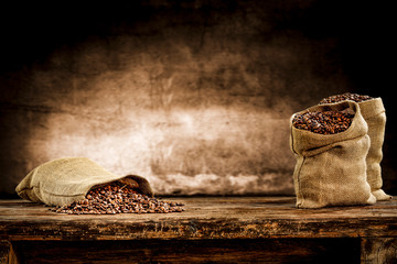 Fresh old sack of coffee grains and brown old wall background 