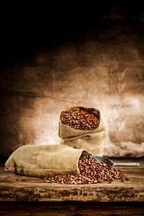Fresh old sack of coffee grains and brown old wall background 