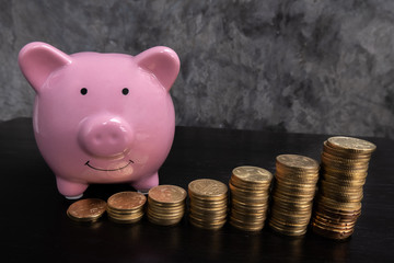 Pink piggy bank with bar graph, coin stepping a growing business to success and save for retirement concept