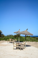 eine Strand Bar mit Sonnenschirmen aus Schilf