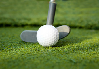 Golfball und Putter einer Minigolfanlage