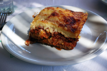 moussaka with aubergine on a dish. traditional greek meal on a table