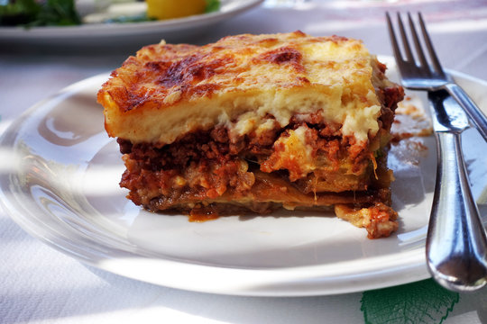 Moussaka With Aubergine On A Dish. Traditional Greek Meal On A Table