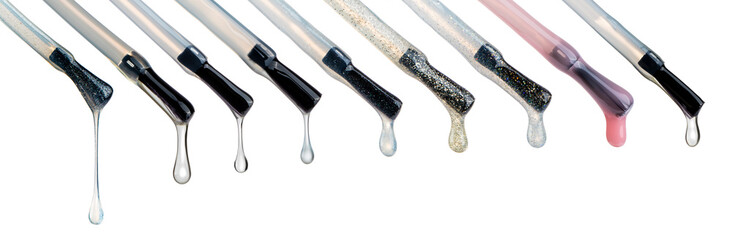 Lacquer drops at the tip of the brush. Different colored vicious liquid drops. Nail care technique, glitter and shimmer liquids. Beautiful transparent blobs isolated on white