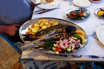 grilled red snapper on a dish with salad on a rustic dish