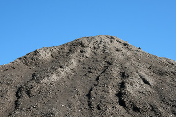 Pile of grey ash material blue sky background