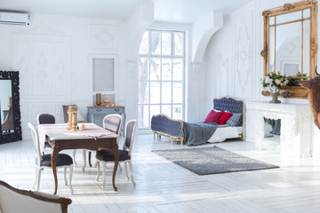 A spacious bright living room with a stylish modern design with elements of antique decor and beautiful chic furniture