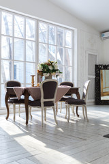 A spacious bright living room with a stylish modern design with elements of antique decor and beautiful chic furniture