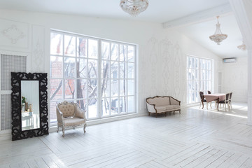 A spacious bright living room with a stylish modern design with elements of antique decor and beautiful chic furniture