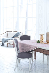 A spacious bright living room with a stylish modern design with elements of antique decor and beautiful chic furniture