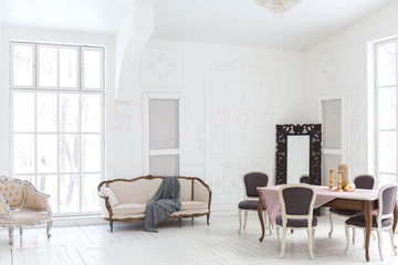 A spacious bright living room with a stylish modern design with elements of antique decor and beautiful chic furniture