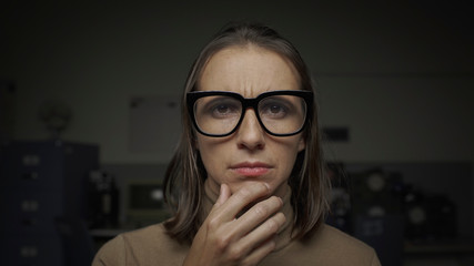 Puzzled woman thinking with hand on chin